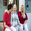 Pflegekräfte plaudern mit Senior