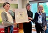 Zertifizierter Lebensort Vielfalt: Kristin Marquart von der Schwulenberatung Berlin überreicht das Siegel an Einrichtungsleiterin Daniela Nagengast-Baumann und Vorständin Marion Leichtle-Werner. 